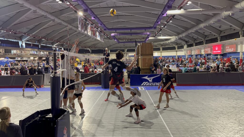 Andon in mid-air ready to spike a ball mid-set.